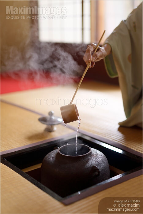 Japanese tea ceremony master pouring steaming water from a kettle with a ladle in a traditional tea house Stock photo of Japanese tea ceremony master pouring steaming water from a kettle with a ladle in a traditional tea house Buy commercial use license at MaximImages