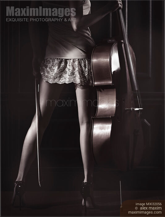 Stock photo of Legs of a sexy young woman in a night gown holding a cello in a dark room with dramatic light Buy commercial use license at MaximImages