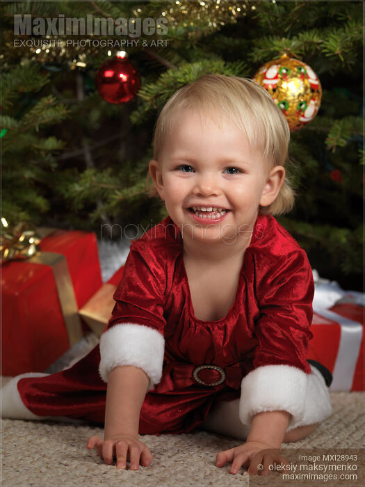 Stock photo of Little Girl near a Christmas Tree Buy commercial use license at MaximImages