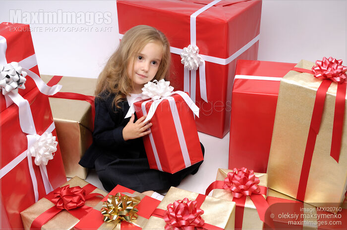 Stock photo of Little girl surrounded by Christmas gifts Buy commercial use license at MaximImages