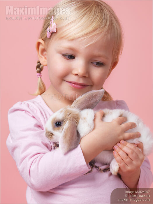 Stock photo of Little girl with a bunny Buy commercial use license at MaximImages