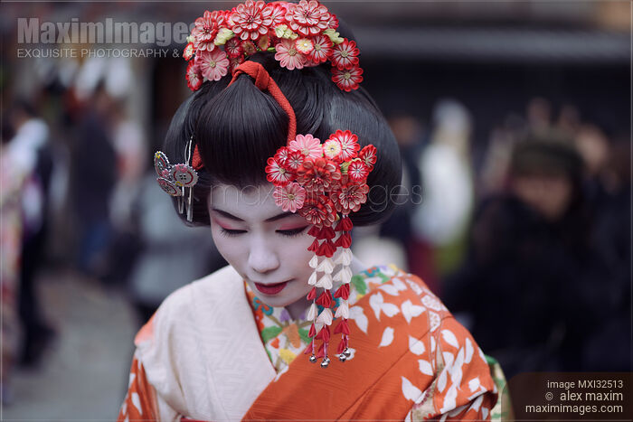 Maiko apprentice Geisha beautiful face with white makeup and red Kanzashi hairpins in her wig bowing her head Stock photo of Maiko apprentice Geisha beautiful face with white makeup and red Kanzashi hairpins in her wig bowing her head Buy commercial use license at MaximImages