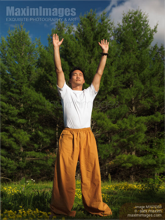 Stock photo of Man practicing sunrise Qi Gong meditation Buy commercial use license at MaximImages