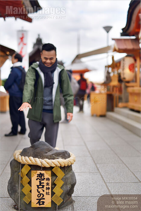 Stock photo of Man walking towards love stone at Jishu Jinja matchmaking shrine at Kiyomizu-dera temple Kyoto Buy commercial use license at MaximImages