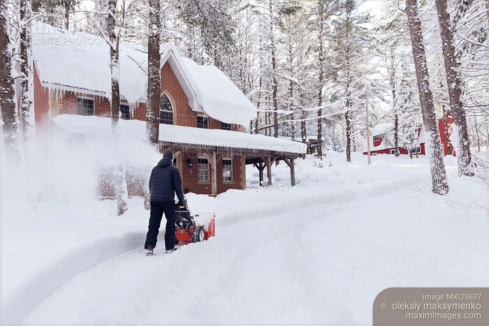 Man with snow thrower clearing driveway near house Stock photo of Man with snow thrower clearing driveway near house Buy commercial use license at MaximImages
