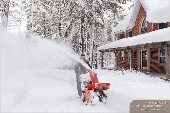 Stock photo of Man with snowblower clearing driveway from snow Buy commercial use license at MaximImages