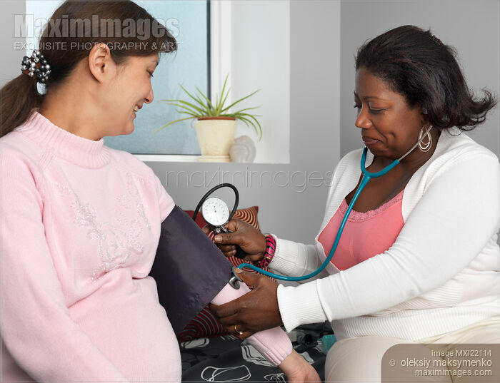 Stock photo of Midwife Measuring Pregnant Woman's Blood Pressure Buy commercial use license at MaximImages