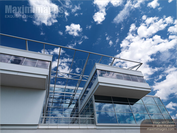 Stock photo of Modern building of glass and metal under blue sky with clouds Buy commercial use license at MaximImages