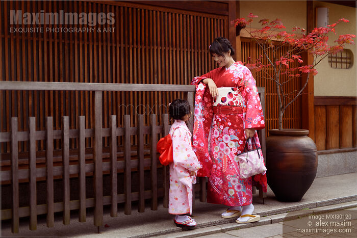 Stock photo of Mother and daughter wearing red Japanese yuakata kimonos on the street Gion Kyoto Japan Buy commercial use license at MaximImages