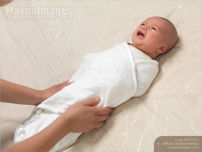 Photo of Mother Swaddling a Baby Stock Image MXI21974