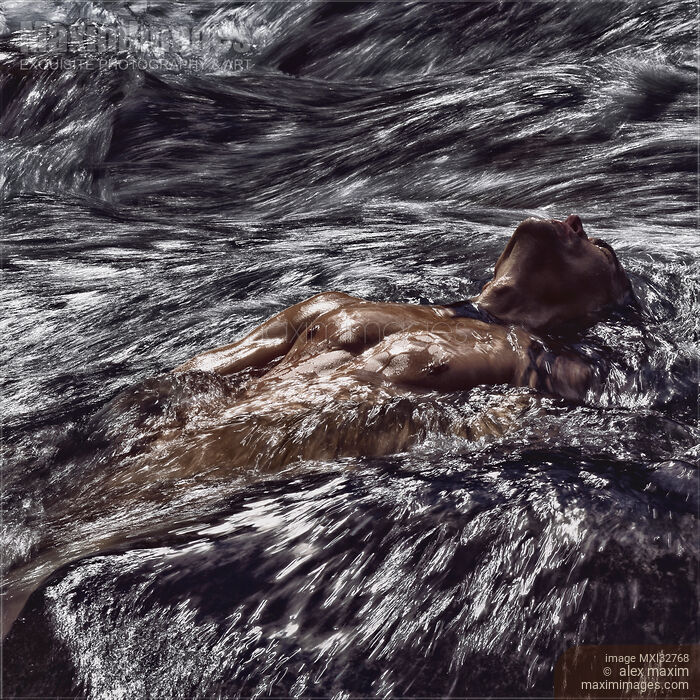 Stock photo of Muscular man half nude body wet bare torso lying in turbulent water of river or stormy sea waves Dynamic moody photo Buy commercial use license at MaximImages