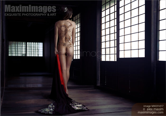 Stock photo of Mysterious asian woman with a dragon body tattoo art on her naked back undressed in a dark Japanese house Yakuza lady Buy commercial use license at MaximImages