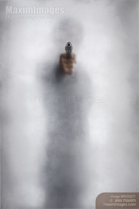 Mysterious man behind glass pointing a gun out of bright white light Thriller and Crime concept Stock photo of Mysterious man behind glass pointing a gun out of bright white light Thriller and Crime concept Buy commercial use license at MaximImages