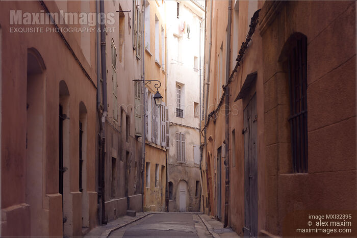 Stock photo of Narrow passage between old crooked houses on a street of a French city Aix-en-Provence Buy commercial use license at MaximImages