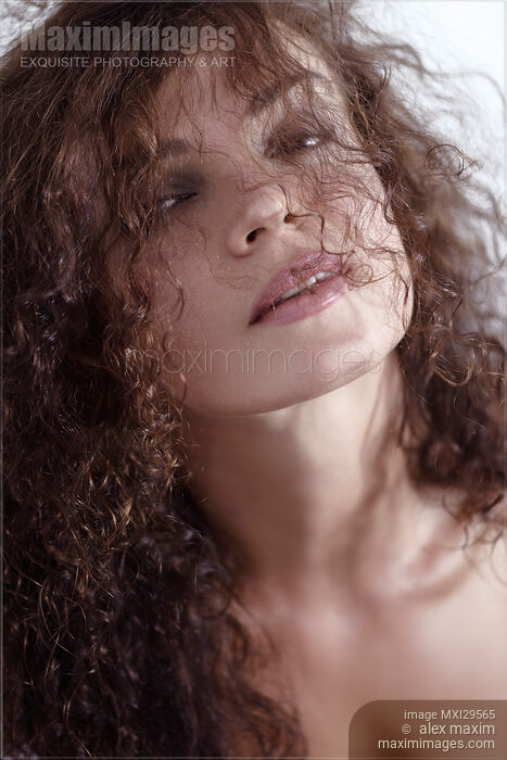 Natural beauty portrait of curly long hair covering young woman face Stock photo of Natural beauty portrait of curly long hair covering young woman face Buy commercial use license at MaximImages