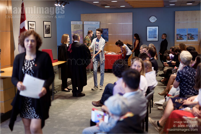 New Canadian citizens receiving their Citizenship certificates at a Citizenship ceremony Stock photo of New Canadian citizens receiving their Citizenship certificates at a Citizenship ceremony Buy commercial use license at MaximImages
