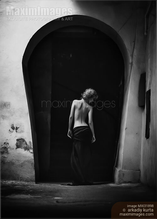 Nostalgic fine art portrait of a young woman standing with her back in an old archway Stock photo of Nostalgic fine art portrait of a young woman standing with her back in an old archway Buy commercial use license at MaximImages