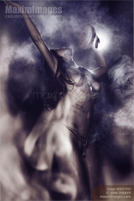Nude aboriginal tribal woman shamanic purification ritual with a drum dancing at night in front of bonfire on full moon