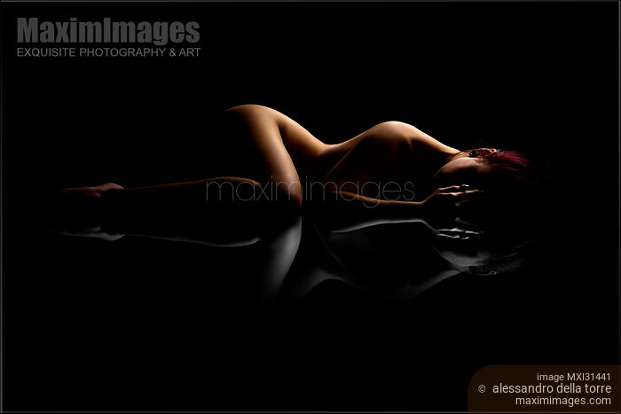 Stock photo of Nude woman body outline on black background with black and white reflection Buy commercial use license at MaximImages