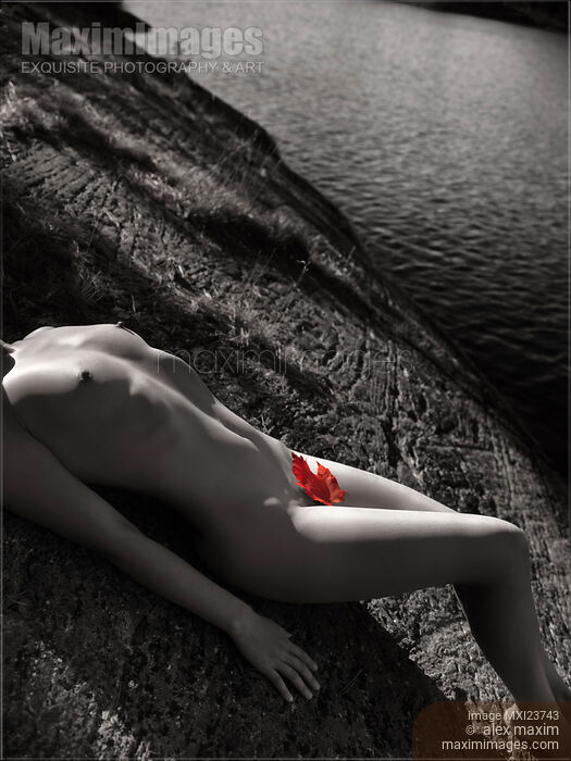 Nude Woman Lying on Rocks by the Water Stock photo of Nude Woman Lying on Rocks by the Water Buy commercial use license at MaximImages