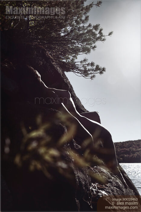 Stock photo of Nude woman lying on rocks in sunshine Buy commercial use license at MaximImages