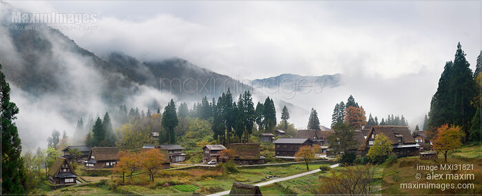 Stock photo of Panoramic foggy morning scenery of Ainokura Japanese mountain farm village with Gassho style houses in autumn Buy commercial use license at MaximImages