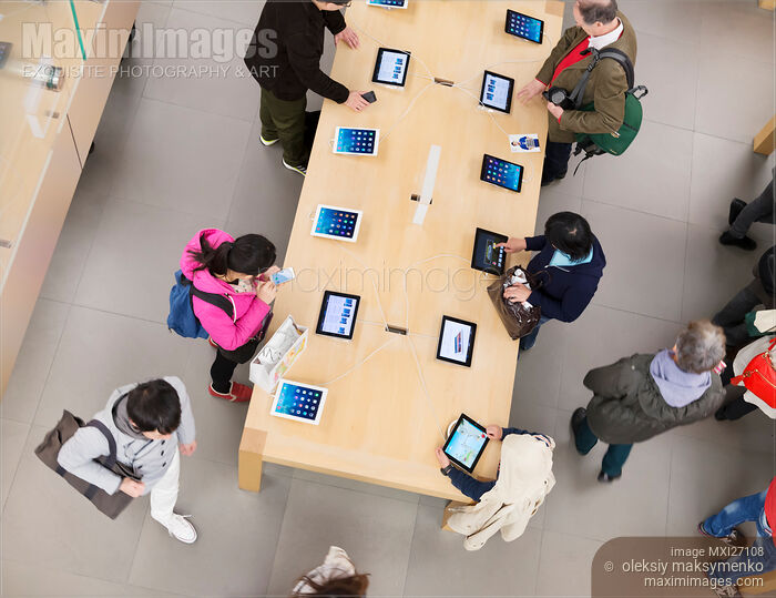 Stock photo of People at Apple store trying new iPad tablets Buy commercial use license at MaximImages
