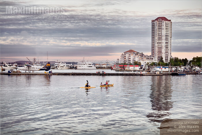 Stock photo of People kayaking at sunset in Nanaimo city waterfront Vancouver Island Buy commercial use license at MaximImages