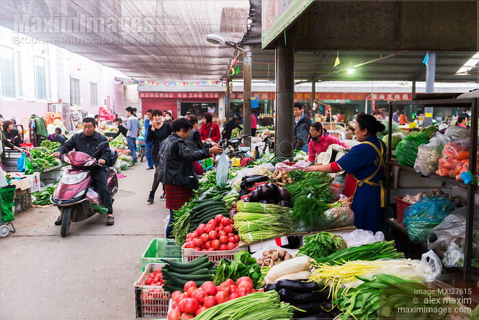 People selling vegetables at food market in China Stock photo of People selling vegetables at food market in China Buy commercial use license at MaximImages