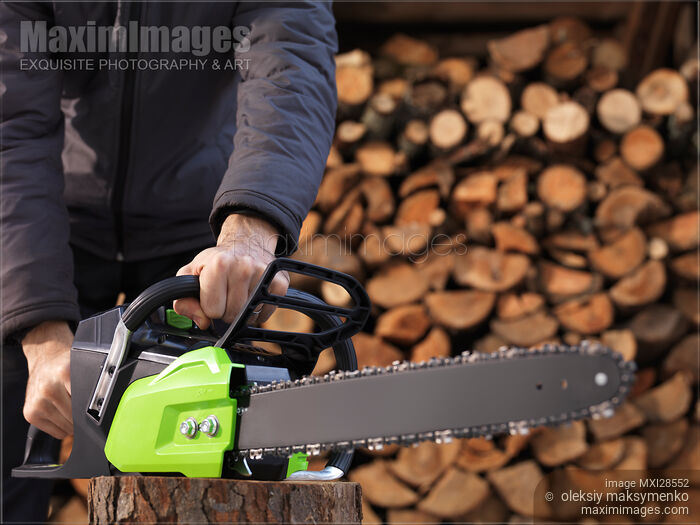 Stock photo of Person holding Electric Chainsaw Buy commercial use license at MaximImages