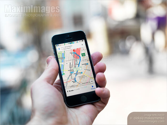 Stock photo of Person holding iPhone with GPS maps in hand Buy commercial use license at MaximImages