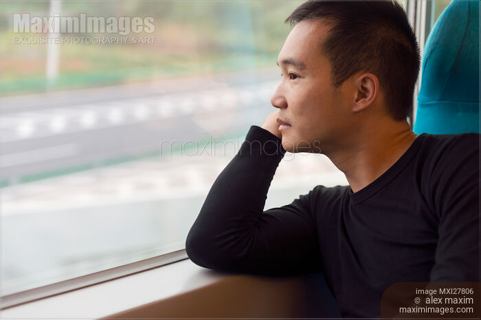 Stock photo of Person looking out of a window of a high-speed train Buy commercial use license at MaximImages