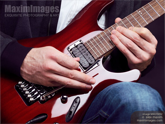 Stock photo of Person playing electric guitar Buy commercial use license at MaximImages
