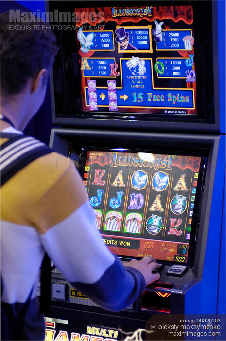 Stock photo of Person Playing Slot Machine in Casino Buy commercial use license at MaximImages