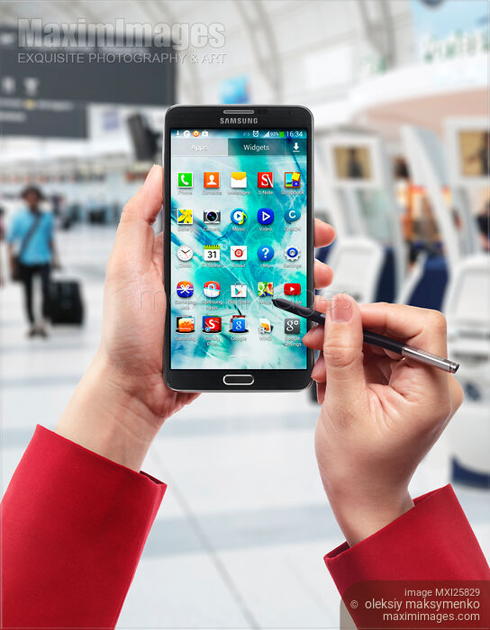 Stock photo of Person using Samsung smartphone at airport Buy commercial use license at MaximImages