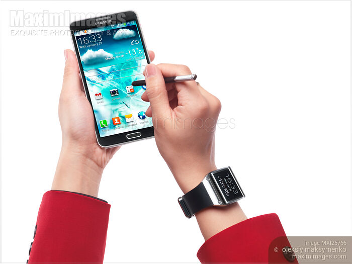 Stock photo of Person with Samsung Galaxy Note III smartphone and Galaxy Gear watch Buy commercial use license at MaximImages