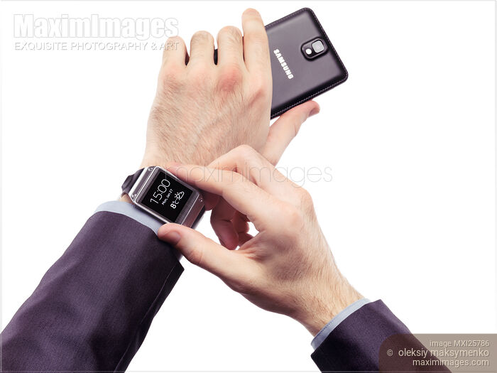 Stock photo of Person with Samsung smartphone and Galaxy Gear watch Buy commercial use license at MaximImages