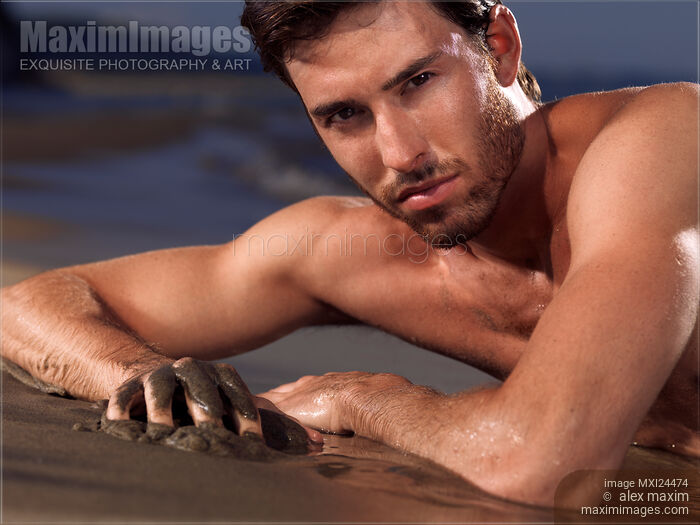 Stock photo of Portrait of a man lying on a sea shore Buy commercial use license at MaximImages