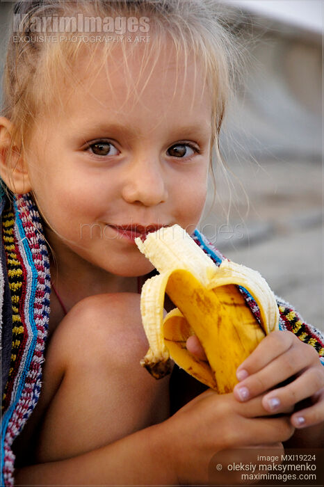 Stock photo of Portrait of child eating a banana Buy commercial use license at MaximImages