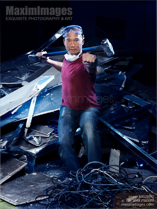 Stock photo of Portrait of man in Kung Fu stance with sledgehammer at demolition work Buy commercial use license at MaximImages