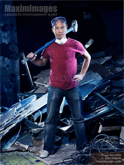 Stock photo of Portrait of man with sledgehammer at renovation site Buy commercial use license at MaximImages