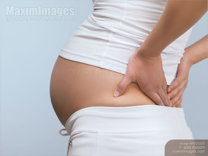 Pregnant woman experiencing backache Stock photo of Pregnant woman experiencing backache Buy commercial use license at MaximImages