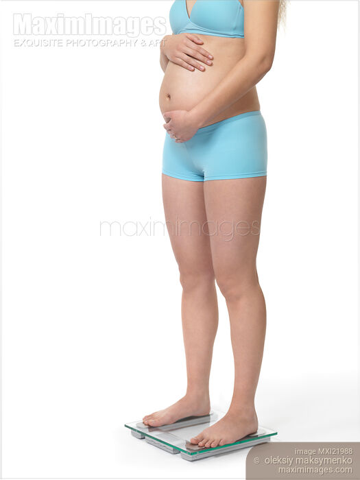Stock photo of Pregnant Woman on a Weight Scale Buy commercial use license at MaximImages