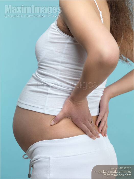 Pregnant Woman Rubbing Her Back Stock photo of Pregnant Woman Rubbing Her Back Buy commercial use license at MaximImages