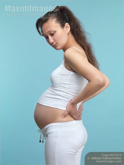 Stock photo of Pregnant Woman Rubbing Her Back Buy commercial use license at MaximImages