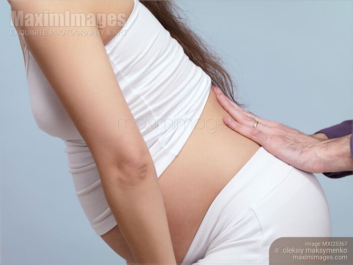 Stock photo of Pregnant woman with back pain getting massage Buy commercial use license at MaximImages