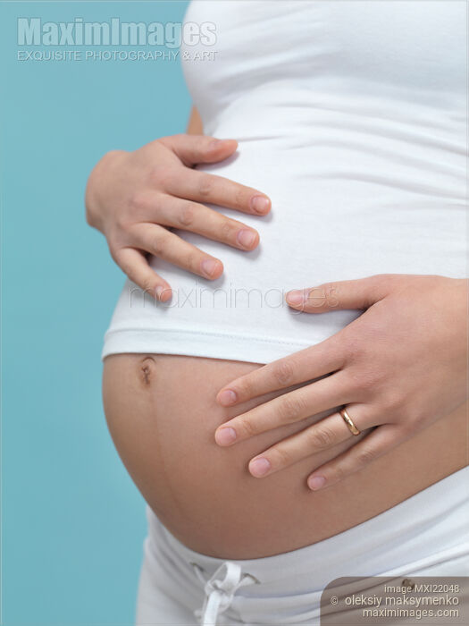 Stock photo of Pregnant Woman with Hands Around Her Belly Buy commercial use license at MaximImages