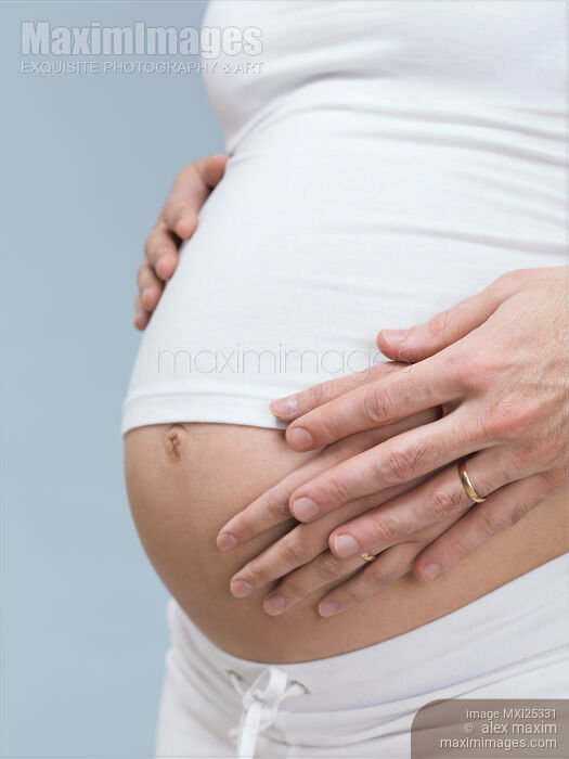 Stock photo of Pregnant Woman with Hands On Her Belly Buy commercial use license at MaximImages