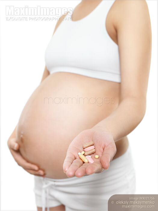 Stock photo of Pregnant Young Woman Holding Pills in Her Hand Buy commercial use license at MaximImages