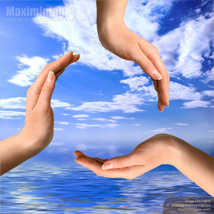 Stock photo of Recycling symbol from hands over blue sky Buy commercial use license at MaximImages
